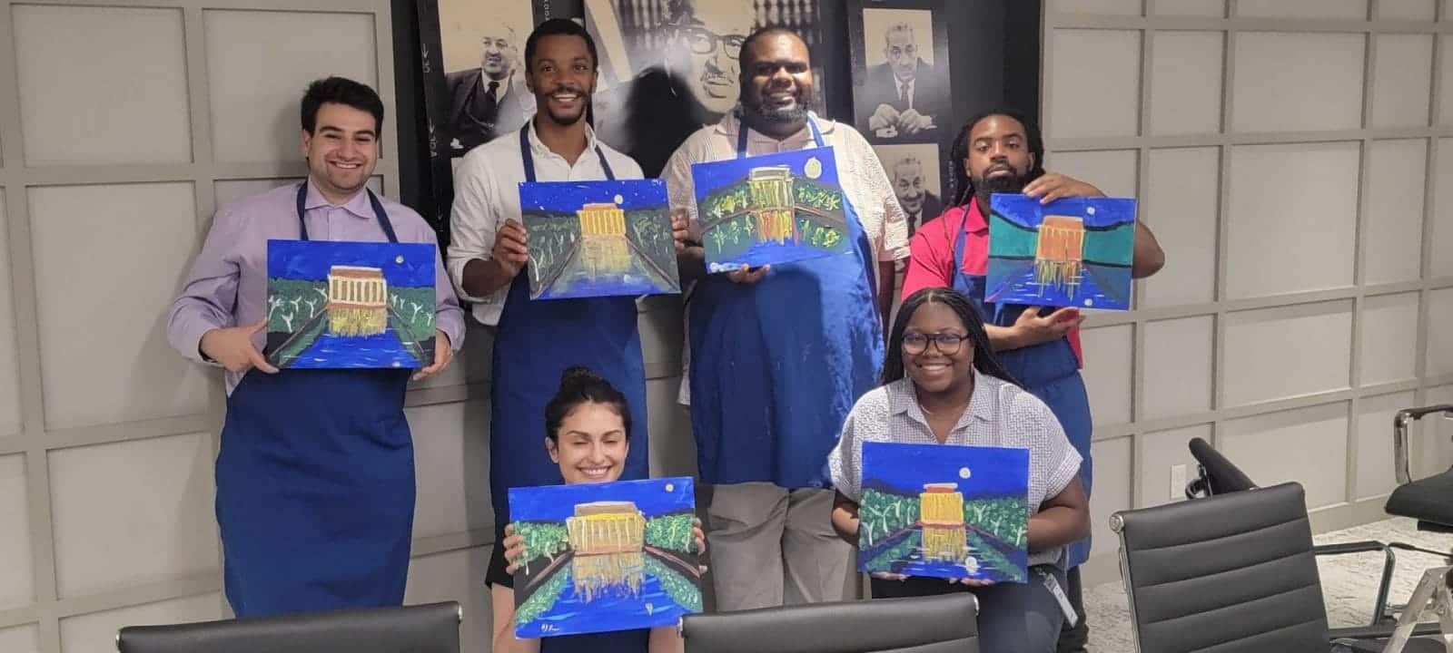 A group of people participating in a paint and sip event in an office.