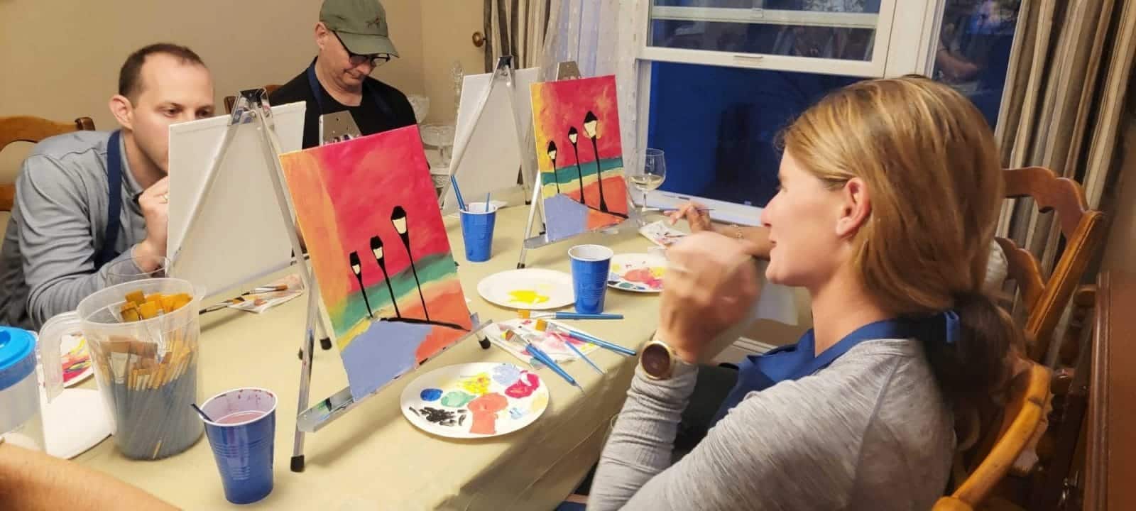 A paint and sip group enjoying a creative session at a table.
