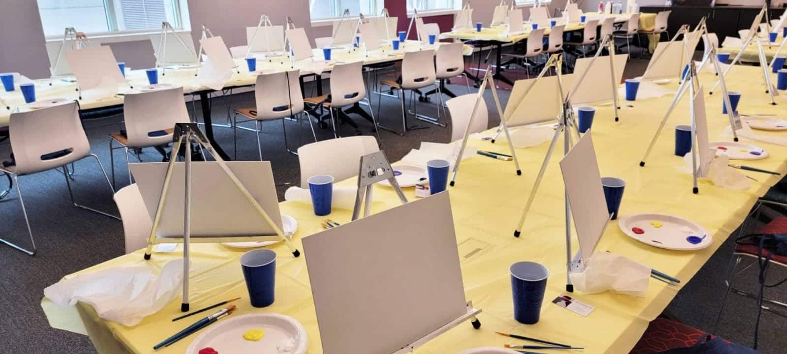 The best paint and sip experience in DC featuring a room full of tables with easels and paints.