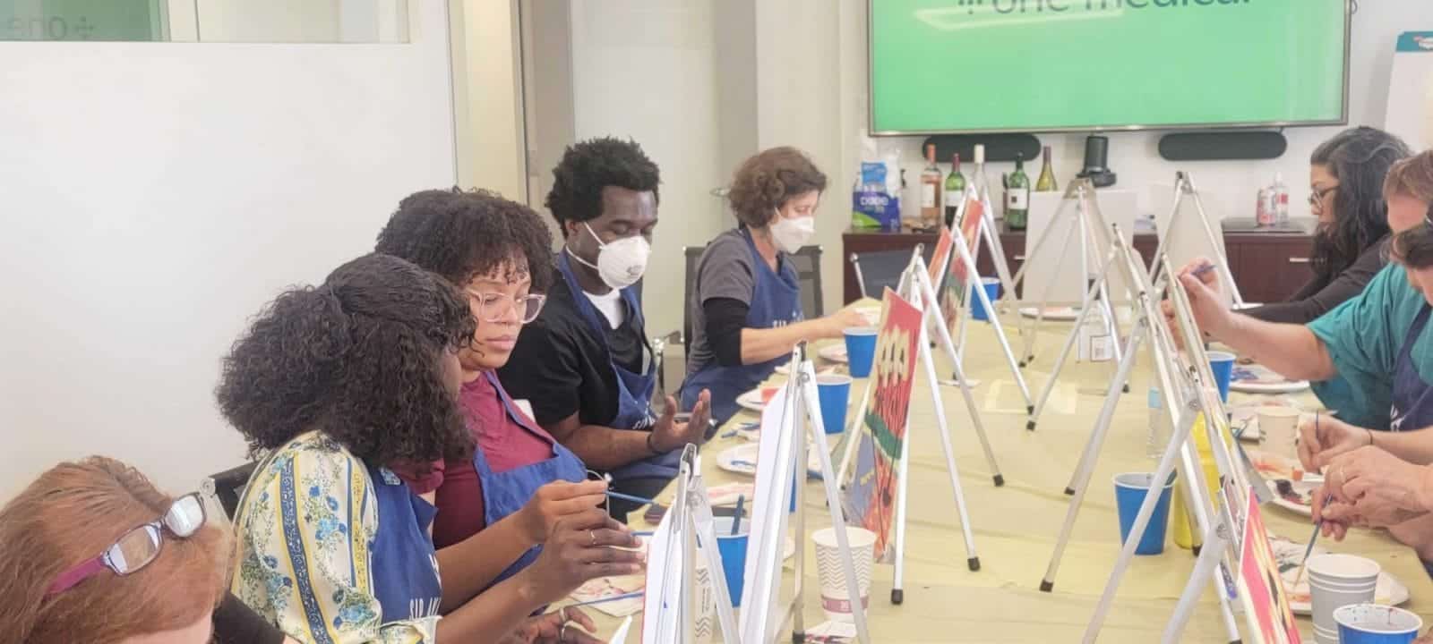 A group of people participating in a sip and paint session.